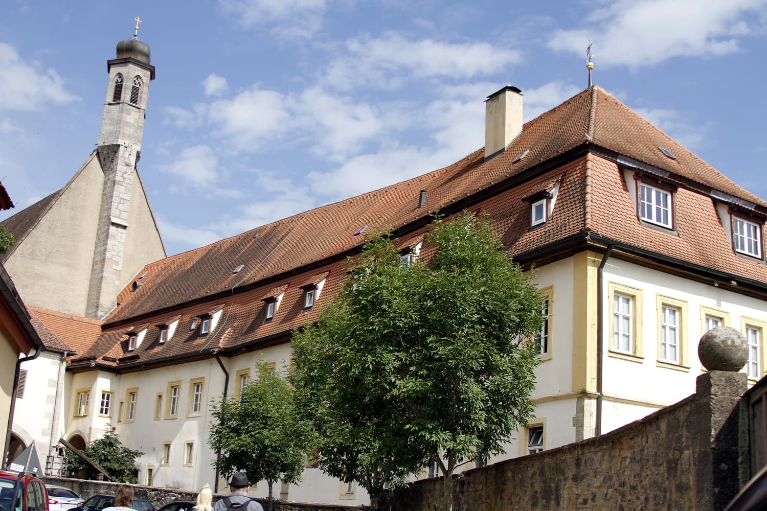 Das Mittelalterliche Kriminalmuseum in Rothenburg, ein langgestrecktes Gebäude mit steilem Ziegeldach neben dem Turm der Franziskanerkirche