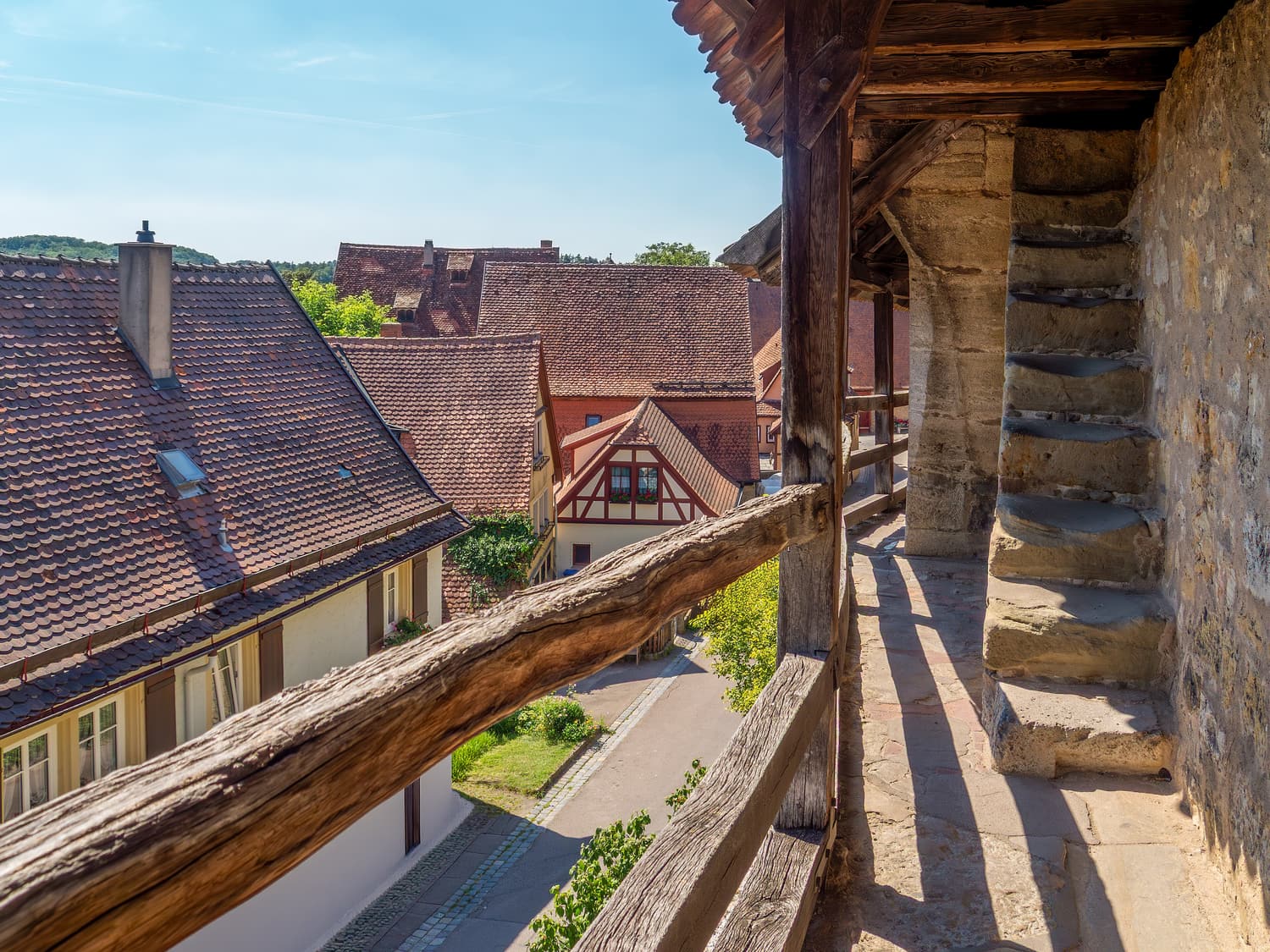 Der überdachte hölzerne Wehrgang auf der Rothenburger Stadtmauer über roten Ziegeldächern