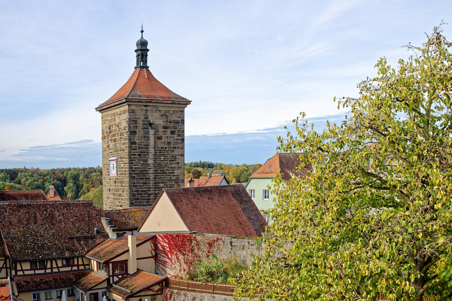 Der Siebersturm über herbstlichen Bäumen und roten Dächern in Rothenburg