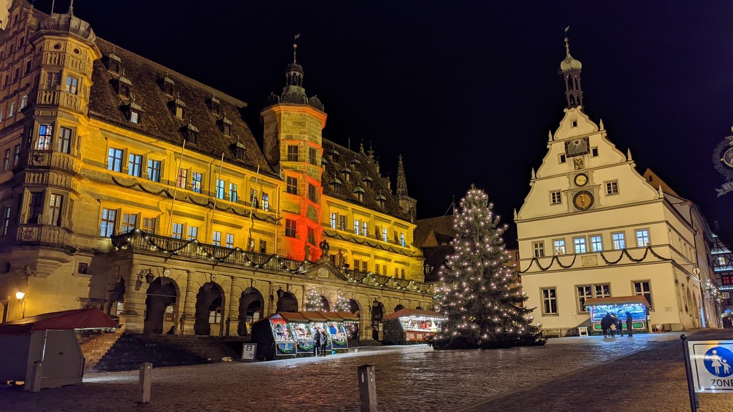 Der Rothenburger Marktplatz mit Rathaus und beleuchtetem Weihnachtsbaum bei Nacht